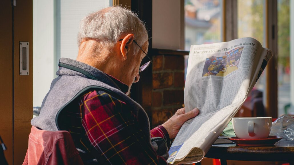 älterer Mann liest Zeitung